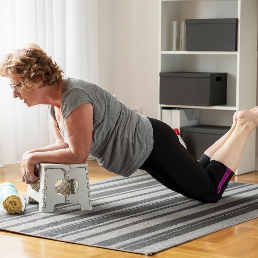 Woman in her 60s working out at home with dumbbells, focused and capable