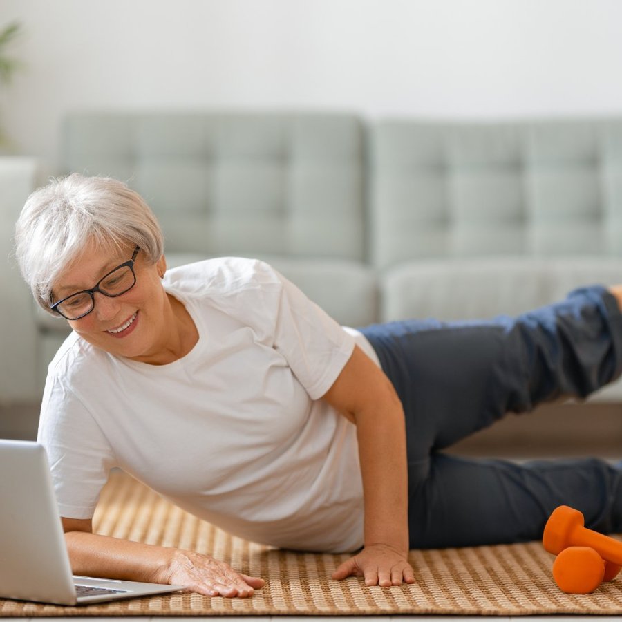A woman comfortably joining a virtual coaching session from home